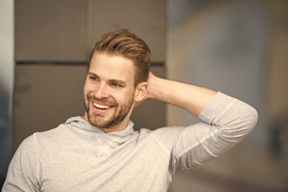 Hombre con cabello cuidado usando productos profesionales para el cuidado capilar masculino